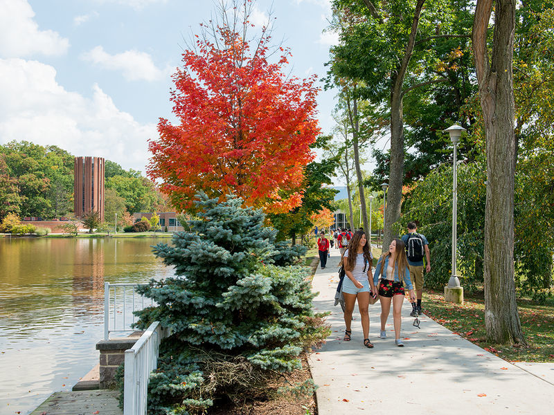 Students walking to and from class by the campus reflecting pond