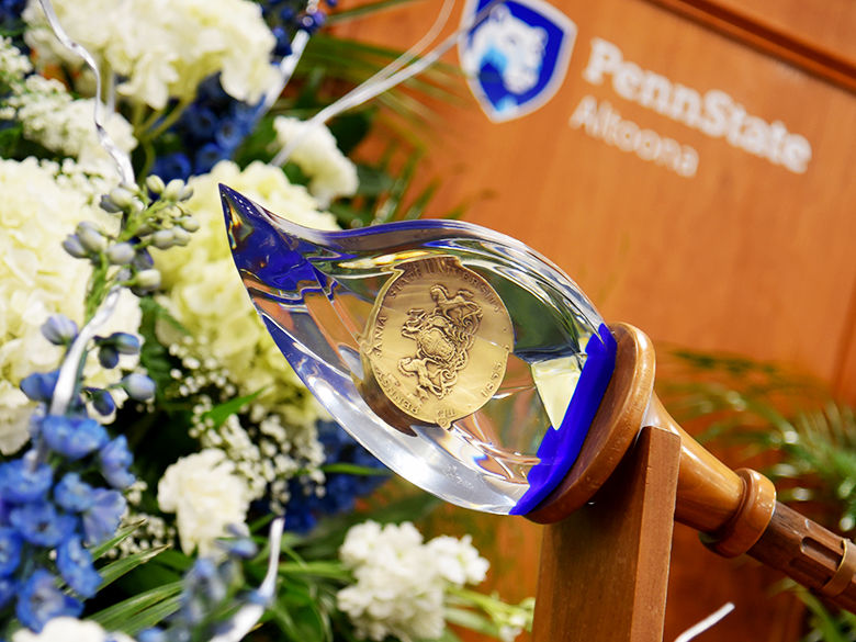 A close-up of the Academic Mace at a commencement ceremony